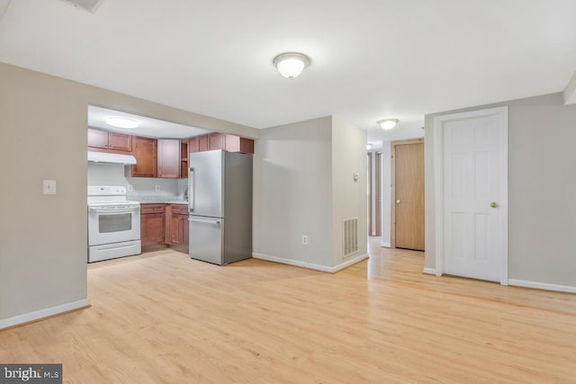 kitchen featuring light wood-type flooring, white range with electric cooktop, and stainless steel fridge