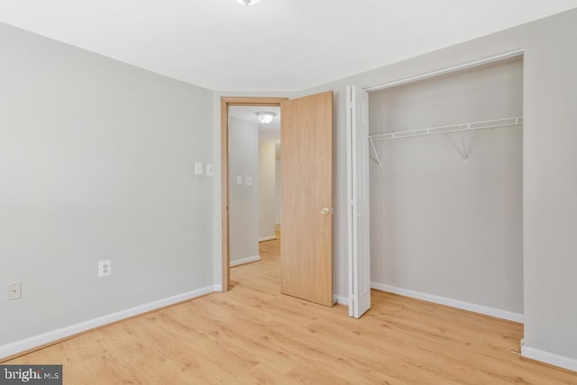 unfurnished bedroom with a closet and light hardwood / wood-style floors