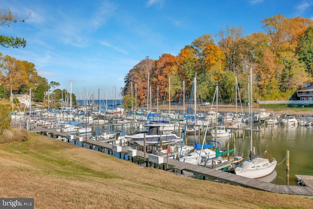 view of dock with a water view and a yard