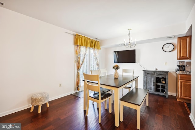 dining area featuring dark hardwood / wood-style flooring and an inviting chandelier