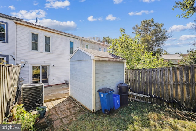 back of house featuring a patio, central AC, and a storage unit