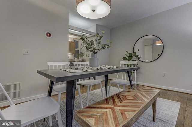 dining space with wood-type flooring