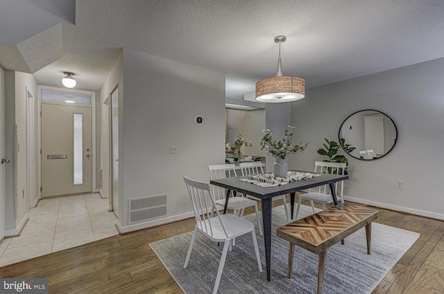 dining area featuring hardwood / wood-style floors and a textured ceiling