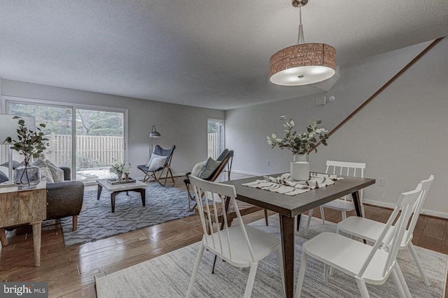 dining room with hardwood / wood-style flooring and a textured ceiling