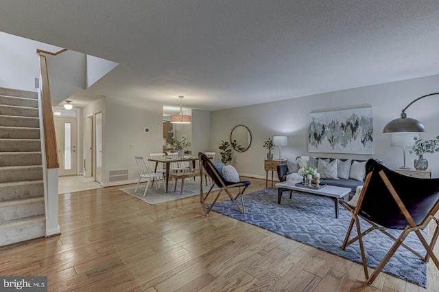 living room featuring a textured ceiling and light wood-type flooring