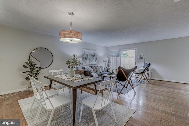 dining room featuring hardwood / wood-style floors and a textured ceiling