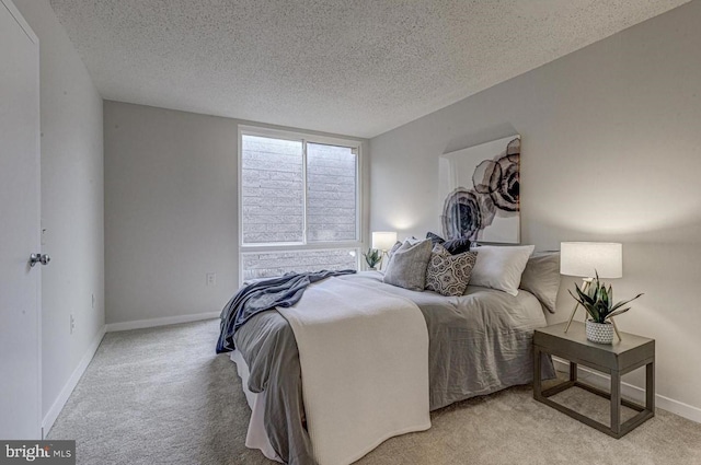 bedroom featuring light colored carpet and a textured ceiling