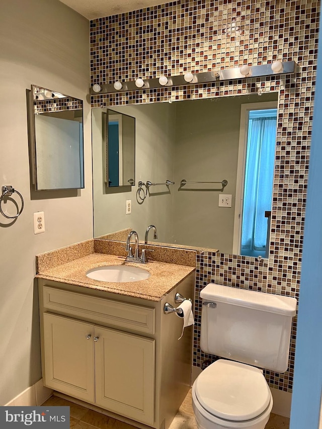 bathroom featuring tile walls, vanity, and toilet