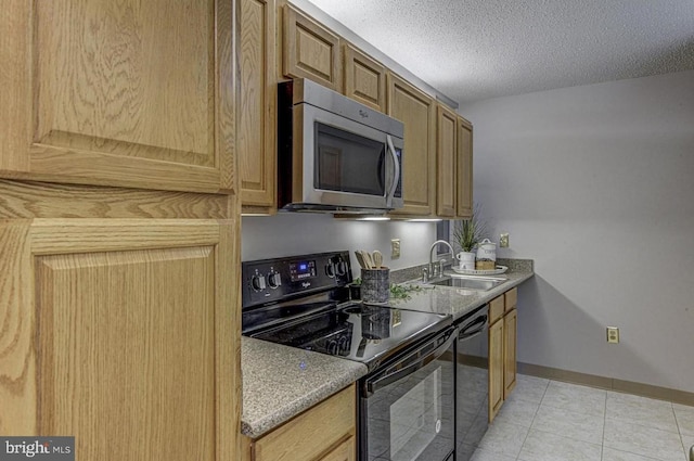 kitchen with sink, light tile patterned floors, a textured ceiling, and black appliances