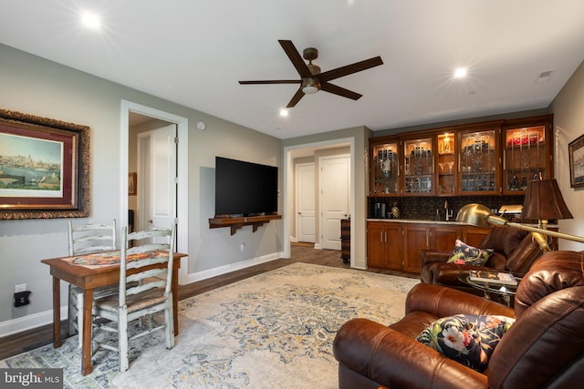 living room with wood-type flooring and ceiling fan