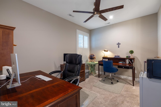 carpeted office space featuring ceiling fan