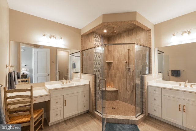 bathroom with wood-type flooring, vanity, and a shower with door