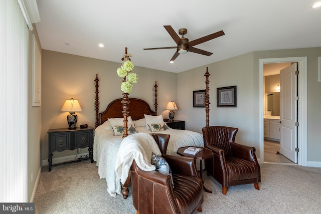 bedroom featuring light carpet, ensuite bath, and ceiling fan