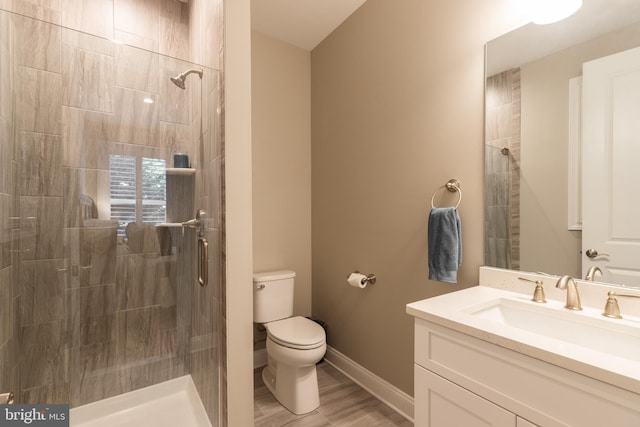 bathroom with hardwood / wood-style flooring, vanity, toilet, and walk in shower