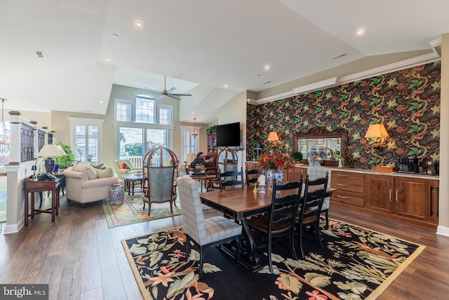 dining room with ceiling fan, dark wood-type flooring, and vaulted ceiling