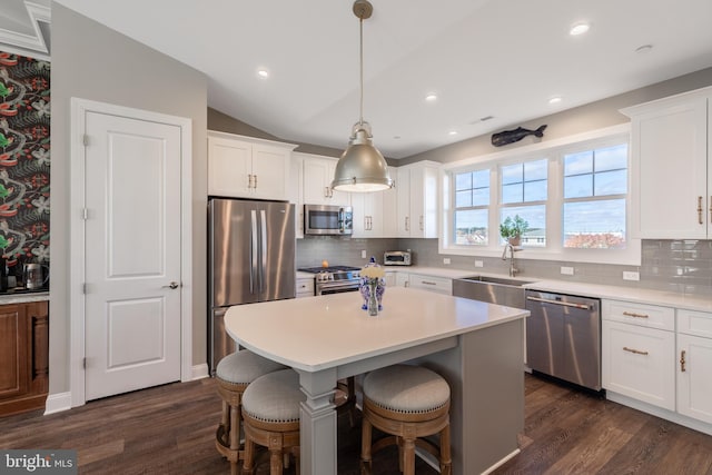 kitchen with sink, dark wood-type flooring, vaulted ceiling, and appliances with stainless steel finishes