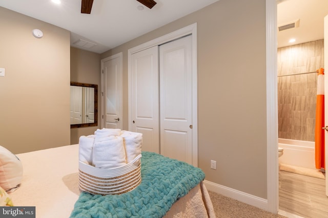 bedroom featuring ceiling fan, a closet, and ensuite bathroom