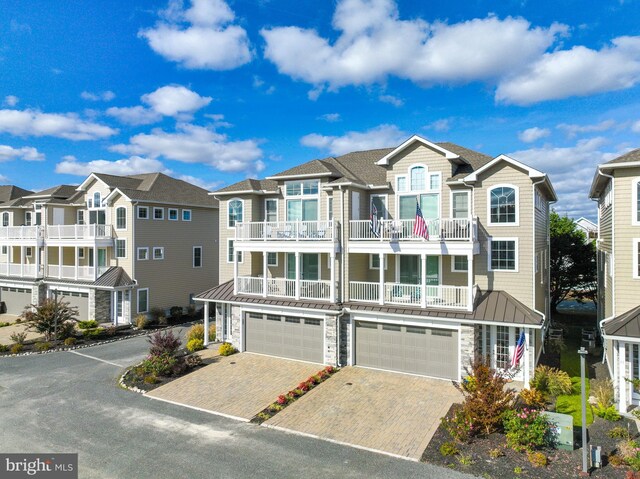 12920 Carmel Ave Unit 10, Ocean City, MD 21842 - view of front of home featuring a garage, stone siding, a balcony, and a standing seam roof