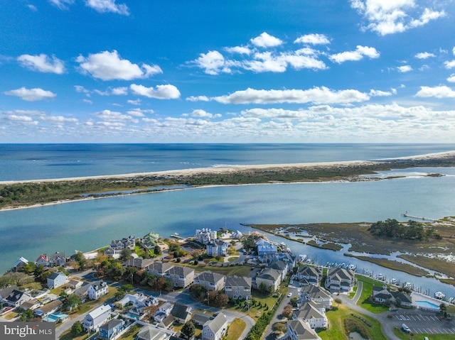 birds eye view of property featuring a water view and a beach view