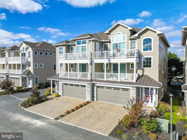 12920 Carmel Ave Unit 10, Ocean City, MD 21842 - townhome / multi-family property with a balcony, an attached garage, driveway, stone siding, and a standing seam roof