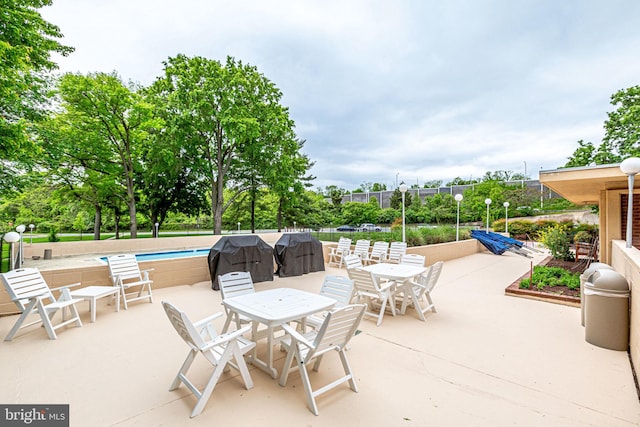 view of patio / terrace with a community pool and a grill