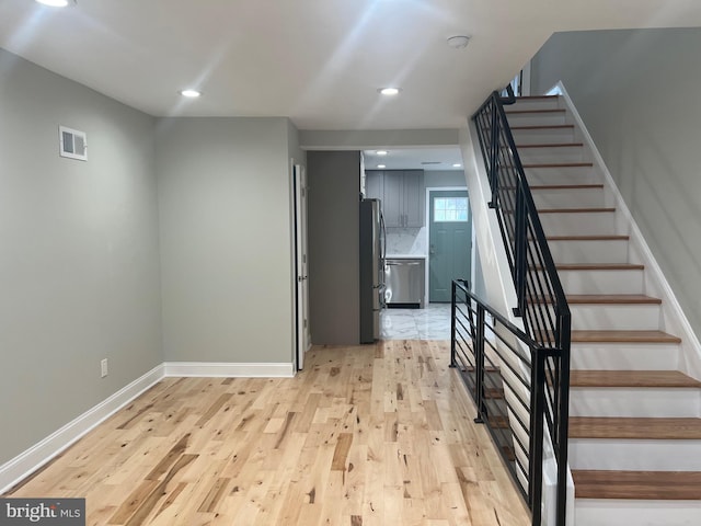 stairway with hardwood / wood-style floors