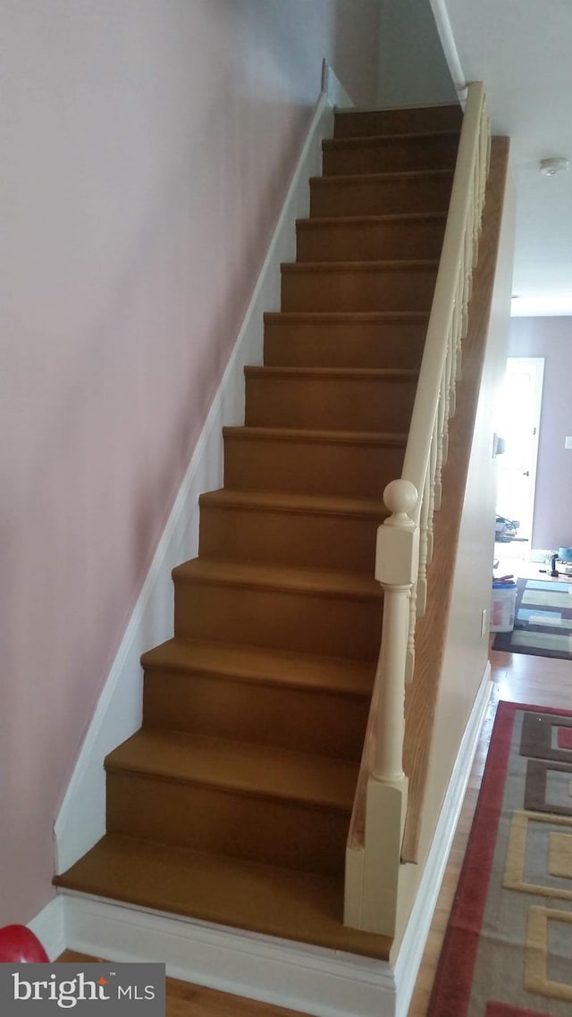 stairs featuring hardwood / wood-style floors