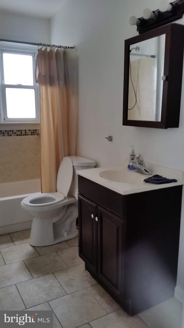 full bathroom featuring vanity, toilet, tile patterned floors, and shower / bath combo with shower curtain