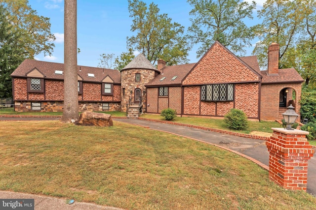 tudor-style house with a front lawn