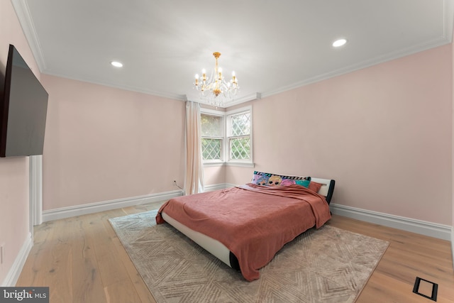 bedroom featuring ornamental molding, an inviting chandelier, and light hardwood / wood-style floors