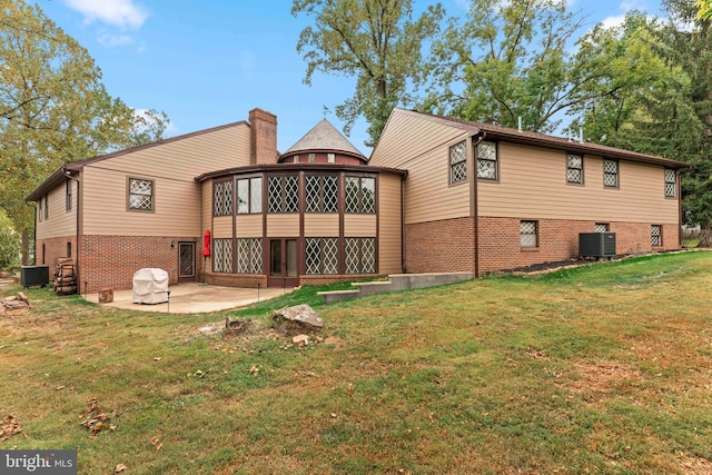 rear view of property with central air condition unit, a patio area, and a lawn