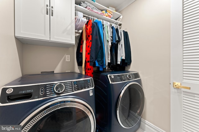 washroom featuring cabinets, crown molding, and washer and dryer