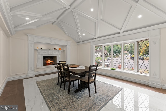 dining room with vaulted ceiling with beams and light hardwood / wood-style flooring