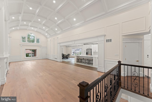 living room featuring ornamental molding, coffered ceiling, light hardwood / wood-style floors, and decorative columns