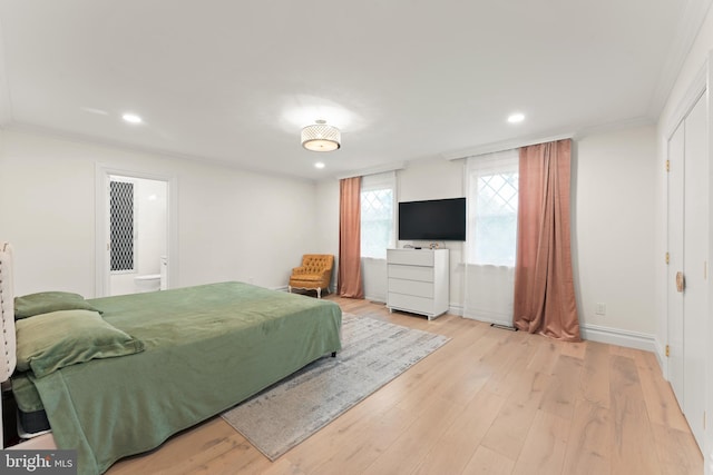 bedroom with light wood-type flooring and crown molding