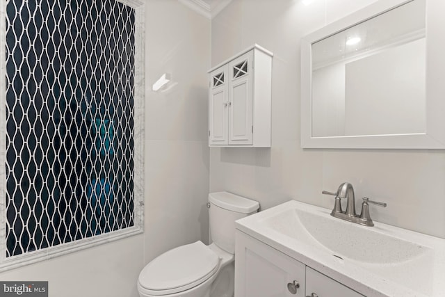 bathroom with vanity, toilet, and ornamental molding