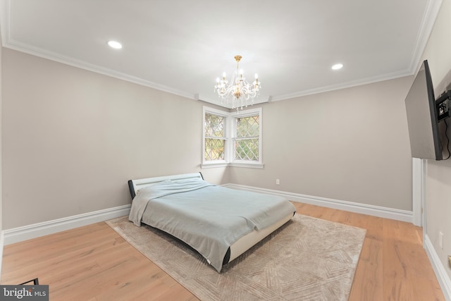 bedroom with an inviting chandelier, wood-type flooring, and ornamental molding