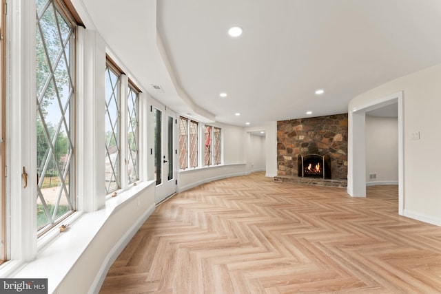 living room featuring light parquet floors and a fireplace