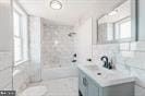 bathroom featuring tiled shower / bath combo, vanity, and a healthy amount of sunlight