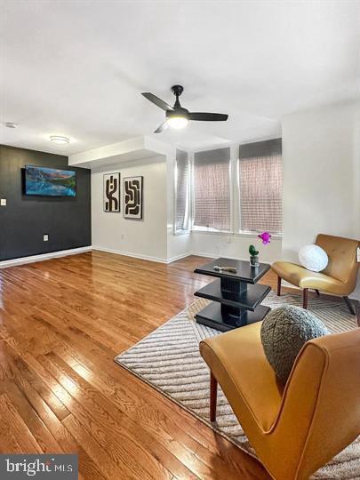 living room with hardwood / wood-style flooring and ceiling fan