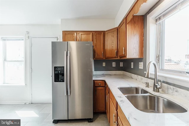 kitchen with sink, plenty of natural light, and stainless steel refrigerator with ice dispenser