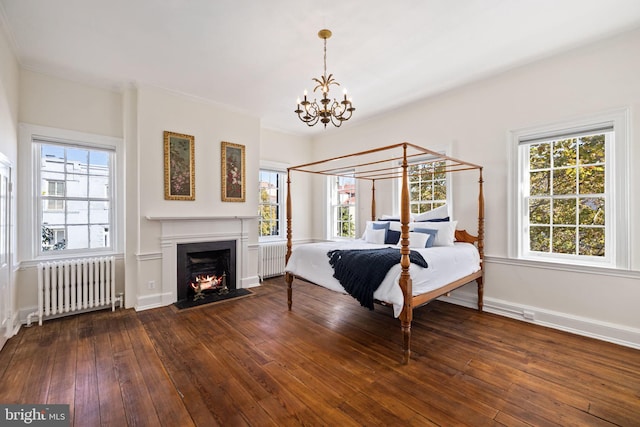 bedroom with dark wood-type flooring, multiple windows, and radiator heating unit