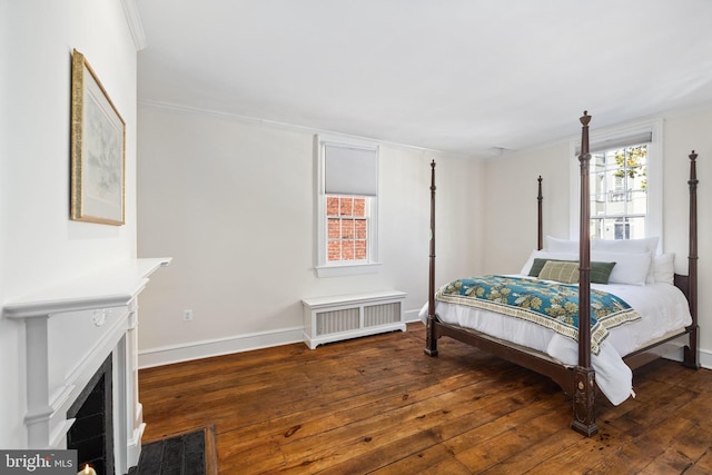 bedroom with crown molding, radiator heating unit, and dark hardwood / wood-style floors