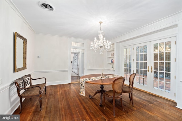 dining room featuring french doors, dark wood-type flooring, ornamental molding, a chandelier, and built in shelves