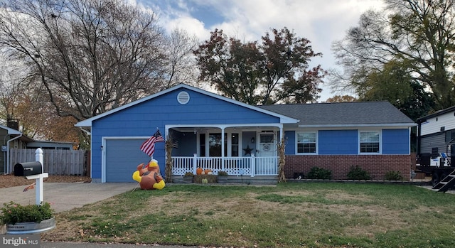 view of front of home with a front lawn, covered porch, and a garage