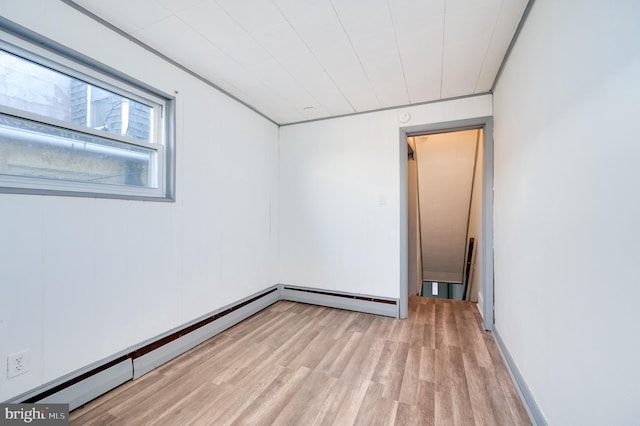 spare room featuring light wood-type flooring and a baseboard heating unit