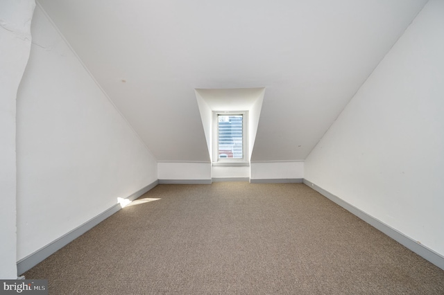 additional living space featuring carpet and lofted ceiling