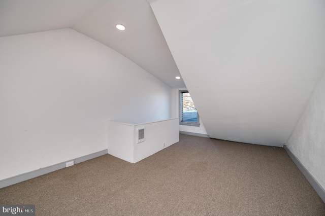 bonus room with lofted ceiling and carpet floors