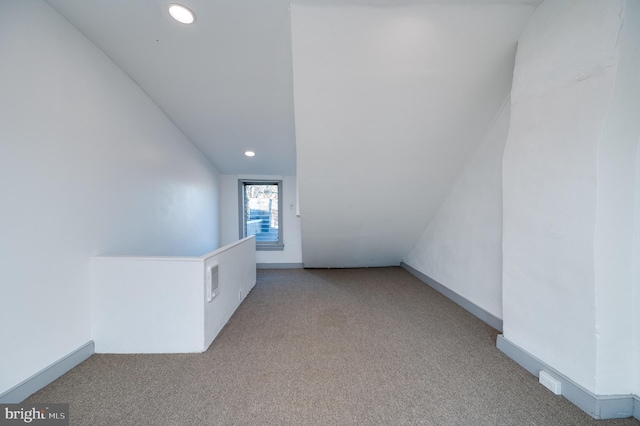 interior space featuring light colored carpet and vaulted ceiling