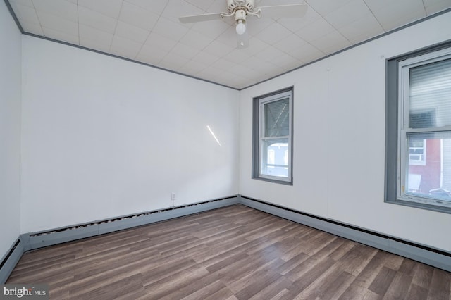 spare room with ceiling fan, wood-type flooring, and a baseboard radiator